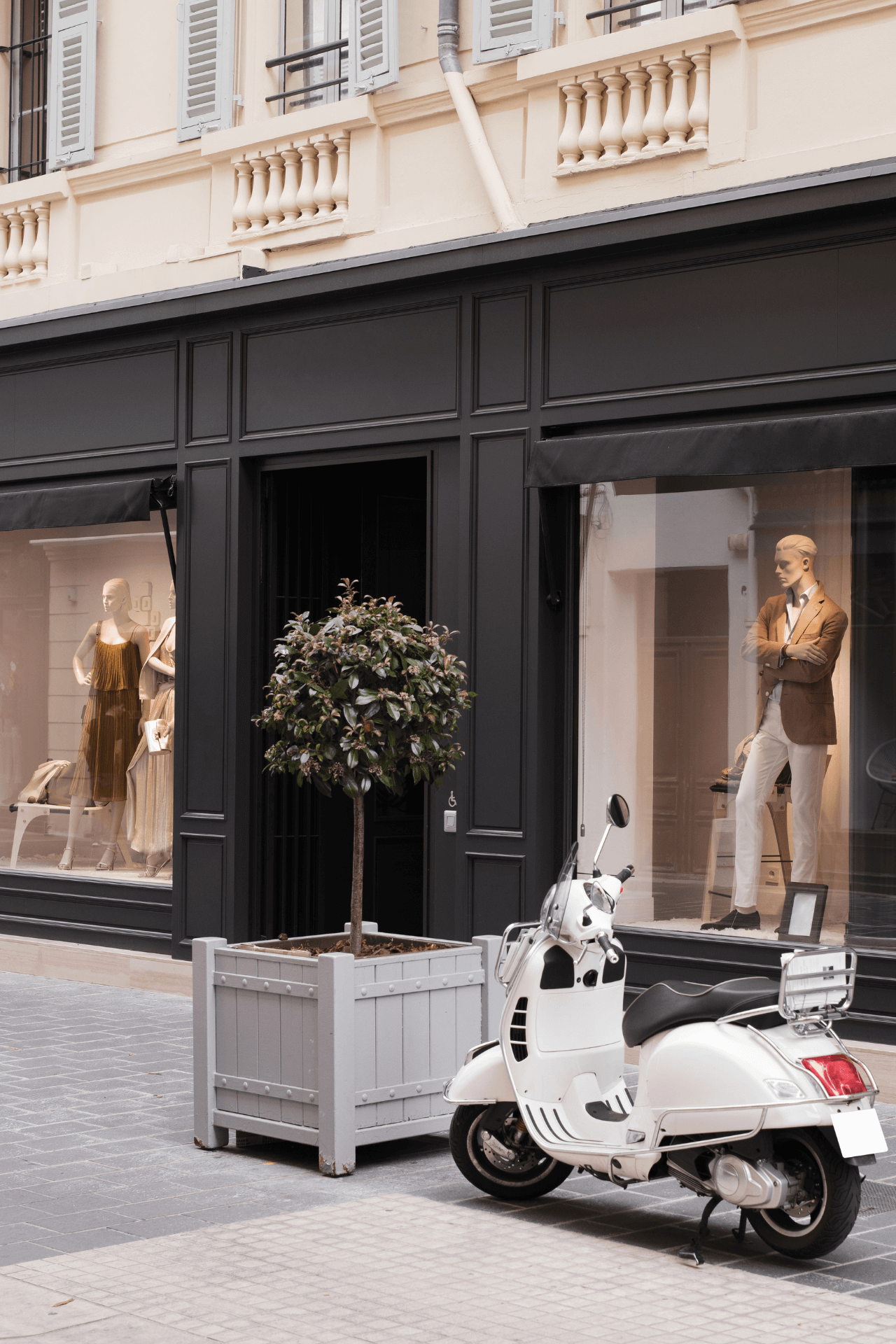 kara-hackett-social-media-fashion-and-retail-shopfront Image of a luxury retail shop front with mannequins in the window and a white moped outside.